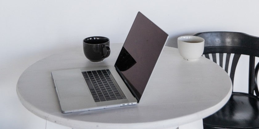 a laptop and a mug of coffee on a table